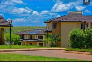 uma casa com painéis solares no telhado em The White Dove - At Migaa Golf Estate em Kiambu