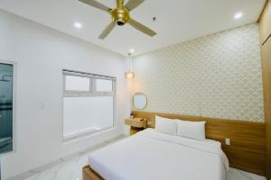 a bedroom with a bed and a ceiling fan at Le's Apartment & Coffee in Da Nang