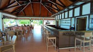 a restaurant with a bar and tables and chairs at Kembali Vista Villa in Fernandez