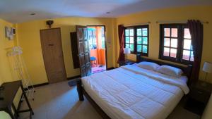 a bedroom with a large bed and yellow walls at Sapparot Bar & Bungalows in Ko Chang