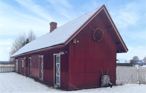 a red barn with a snow covered roof at Beautiful Home In Flisa With Kitchen 