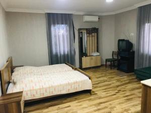 1 dormitorio con 1 cama y TV en Ruslan hotel, en Poti