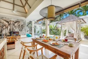 an open kitchen and dining room with a table and chairs at Villa Safari in Seminyak