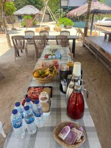 uma mesa de piquenique com comida e garrafas de água em Baan Plai Laem Homesty em Koh Phaluai