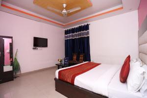 a bedroom with a bed and a flat screen tv at OYO Hotel Kohinoor in New Delhi