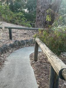 a wooden bench next to a path in a park at Riversong Perth in Perth