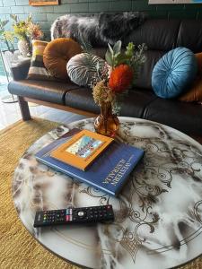 a book and a remote control on a coffee table at Riversong Perth in Perth