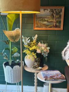 une table avec des vases de fleurs sur elle dans l'établissement Riversong Perth, à Perth