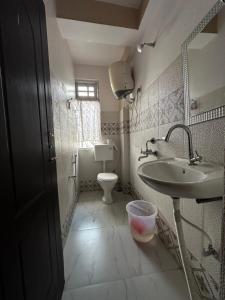 La salle de bains est pourvue d'un lavabo et de toilettes. dans l'établissement Cloudy hills, à Darjeeling