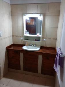a bathroom with a sink and a mirror at POSADA CUATRO HERMANOS in Tinogasta