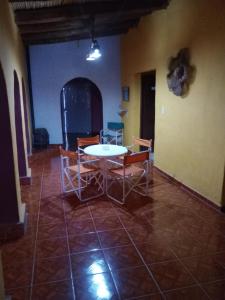 a dining room with a table and chairs in a room at POSADA CUATRO HERMANOS in Tinogasta