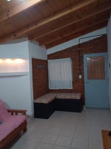 Habitación con 2 camas, ventana y puerta en Lo de Nelly en Puerto Madryn