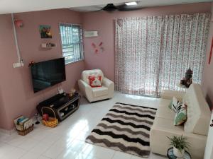 un soggiorno con TV, divano e sedie di Home at Tampin @ A Famosa Resort @ Melaka a Kampong Alor Gajah