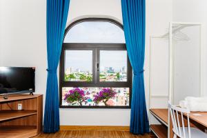 a room with a window with blue curtains at MONTANA HOMESTAY VUNG TAU in Vung Tau