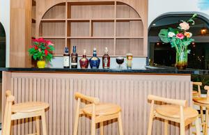 a bar with wooden chairs and bottles of alcohol at MONTANA HOMESTAY VUNG TAU in Vung Tau