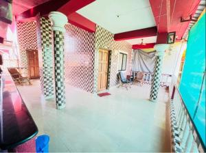 a living room with a red ceiling and a room with chairs at Matilda Guest house in Calangute