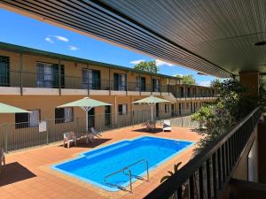 uma piscina em frente a um edifício em The Tower Hotel em Kalgoorlie