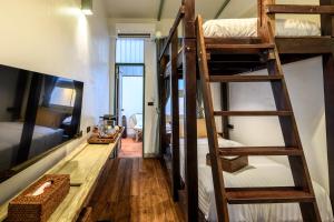 a room with four bunk beds and a table at Hanuman Boutique Stay &Eatery in Hat Yai