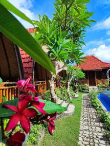 a garden with a house and a yard with trees at Grand Cory in Nusa Penida