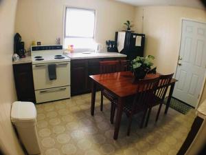 a kitchen with a table and a stove and a refrigerator at Close to Falls, Steps to Casino, Sleeps 7-8 in Niagara Falls