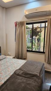 a bedroom with a bed and a window at ApartOfCalcutta! in Kolkata