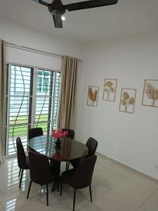 uma sala de jantar com uma mesa de vidro e cadeiras em EV Sweet Holiday Homestay em Malaca