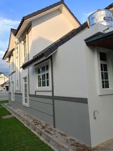 ein weißes Haus mit einer schwarz-weißen Garage in der Unterkunft EV Sweet Holiday Homestay in Malakka
