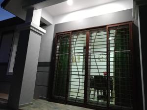 Zimmer mit Glastüren und einer Säule in der Unterkunft EV Sweet Holiday Homestay in Malakka