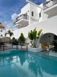 uma piscina em frente a um edifício branco em La Bella Vita Tulum em Tulum