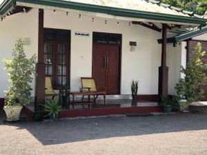 uma pequena casa com duas cadeiras e um alpendre em The Esence of Sri Lanka em Ahungalla