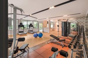 a gym with a lot of exercise equipment in it at Palm Garden Hotel, Putrajaya, a Tribute Portfolio Hotel in Putrajaya
