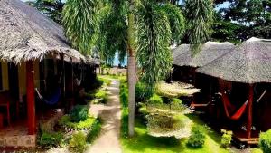un groupe de cabanes avec palmiers et hamacs dans l'établissement AivyMaes Divers Resort, à Dauin