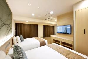Odysis Suites Osaka Airport Hotel客房内的一张或多张床位
