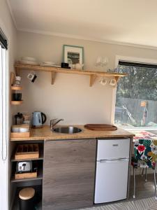 uma cozinha com um lavatório e uma bancada em Kowhai Landing Beach Cabin em Otaki Beach