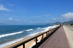 a boardwalk stretches out into the ocean on a beach at Apartamento Praia Massaguaçú in Caraguatatuba