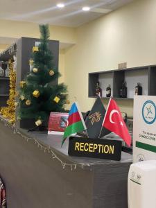 a reception desk with a christmas tree and flags on it at Rahat Hostel in Ganja