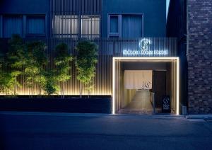 une entrée dans un bâtiment avec un panneau qui nous dit : dans l'établissement Sakura Cross Hotel Kyoto Kiyomizu, à Kyoto