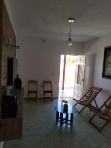 salon ze stołem i krzesłami oraz oknem w obiekcie Casa de praia w mieście Luis Correia