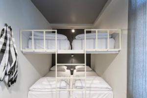 a small room with three bunk beds in it at Tuk Tuk House 250m from MRT Sirikit in Bangkok