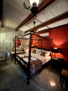 ein Schlafzimmer mit einem Himmelbett und einer roten Wand in der Unterkunft 1A Court Square by AQUA Villa in Galle