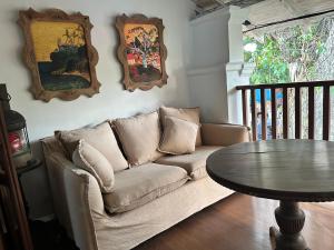 ein Wohnzimmer mit einem Sofa und einem Tisch in der Unterkunft 1A Court Square by AQUA Villa in Galle