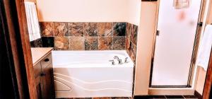 a bathroom with a tub and a sink at Cozy 2 Bedroom 2 Bathroom Ski in Ski out Townhouse in Sun Peaks