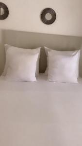 フェルスにあるНураの白い枕と鏡が備わる白いベッド
