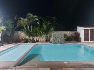 a swimming pool at night with palm trees at Casa Dñ Ana in Jacó