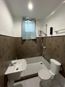 a bathroom with a white toilet and a sink at On Board Panglao Beach Hostel & Resort in Dao