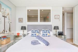 a bedroom with a large white bed with pillows on it at Balmoral Beach Beauty in Sydney