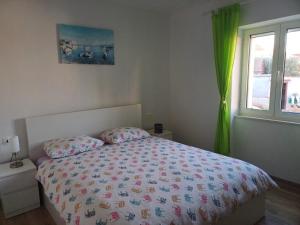 波斯蒂勒的住宿－Apartment Perica - 10 m from sea，一间卧室配有一张带床罩的床和窗户