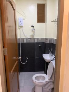 La salle de bains est pourvue de toilettes et d'un lavabo. dans l'établissement ZL TRAVELERS INN, à Batuan