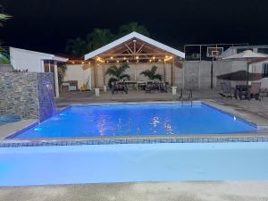 ein großer blauer Pool vor einem Haus in der Unterkunft Casas Dñ Juanita in Jacó