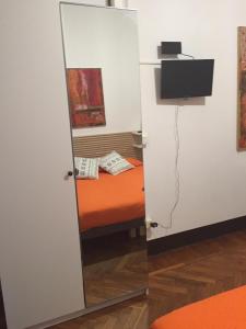 ボローニャにあるB & B 21 Bolognaのベッドとテレビ付きの部屋の鏡